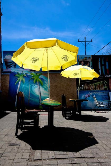 Un café en Jacó con mesas hechas con tablas de surf, deporte que identifica al lugar.