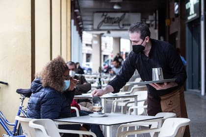Un camarero sirve un café a una clienta en la Cafetería Tristana, en Badajoz, Extremadura. JAVIER PULPO - Europa Press