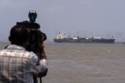 Un camarógrafo graba al petrolero con bandera india LPG Jag Vasant, que lleva gas licuado de petróleo, en el Puerto de Mumbai en Mumbai, India, tras pasar por el estrecho de Ormuz, el miércoles 1 de abril de 2026. (AP Foto/Rafiq Maqbool)