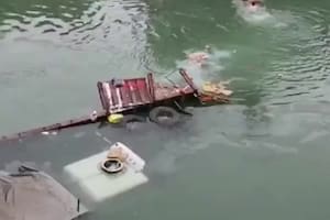 Decenas de personas se tiraron al río para robar la mercadería de un camión que cayó al agua