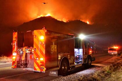 Un camión del Departamento de Bomberos de Los Ángeles se moviliza por la autopista 154 durante las operaciones para combatir las llamas
