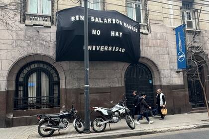 Un cartel en la fachada de la Universidad Nacional de las Artes (UNA), cerrada por el paro, exige salarios dignos
