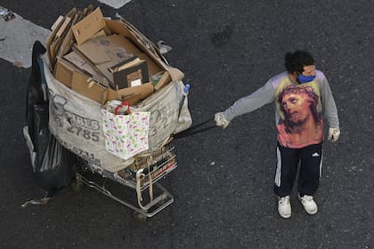 Un cartonero usa una camiseta con el retrato de Jesucristo mientras tira de su carrito durante la cuarentena impuesta por el gobierno contra la propagación del nuevo coronavirus, en Buenos Aires, el 28 de mayo de 2020