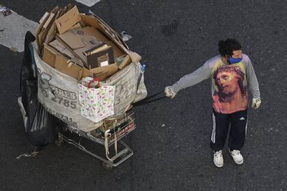 Un cartonero usa una camiseta con el retrato de Jesucristo mientras tira de su carrito durante la cuarentena impuesta por el gobierno contra la propagación del nuevo coronavirus, en Buenos Aires, el 28 de mayo de 2020