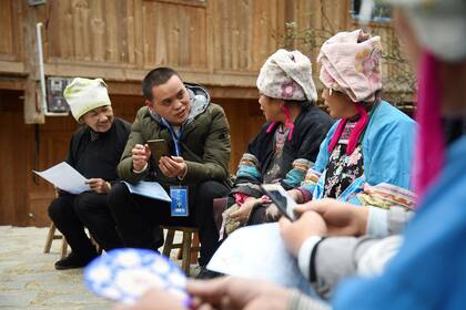 Un censista realiza una encuesta de censo a personas de la minoría étnica Miao en el condado de Rongjiang, en la provincia de Guizhou, suroeste de China.