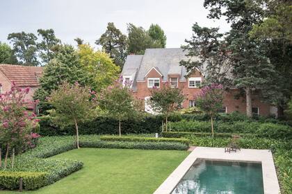 Un cerco de Olea texana al fondo, un cerco de Buxus sempervirens por delante y Trachelospermum jasminoides como cubresuelo. Una serie de Lagerstroemia indica recorre todo el jardín y da la nota vertical.