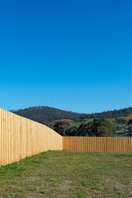 Un cerco hecho con tablas de madera que otorga intimidad