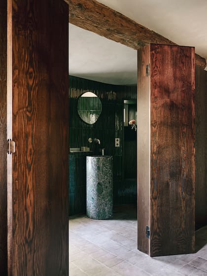 Un cerramiento plegable de madera se enganchó a una de las vigas para determinar el nuevo tamaño del baño principal.