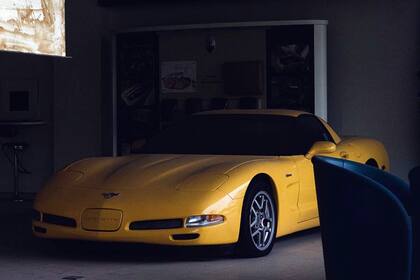 Un Chevrolet Corvette C5 Z06 amarillo entre los sillones de la concesionaria abandonada
