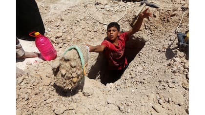 Un chico cava una tumba en el cementerio Wadi al-Salam