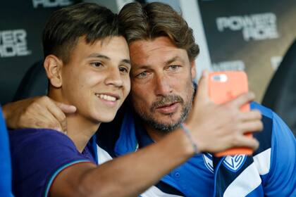 Un chico de las juveniles de Vélez se toma una foto con Heinze en el Amalfitani