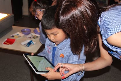Un chico de sala de 5 aprende con la tablet en un jardín de infantes de San Cristóbal