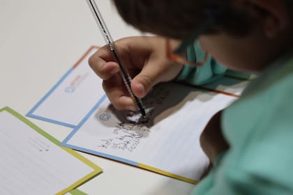 Un chico dedica un kit escolar para un alumno de una escuela rural