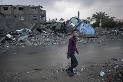 Un chico palestino pasa junto a una mezquita destruida el primer día del festival Eid al-Fitr que marca el final del mes sagrado del Ramadán, en Deir el-Balah, en la zona central de la Franja de Gaza, el 10 de abril de 2024, en medio del conflicto en curso entre Israel y el grupo militante palestino Hamás.(Photo by AFP)