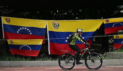 Un ciclista pasa por banderas venezolanas a la venta, en septiembre de 2025; Estados Unidos ya ponía presión sobre el régimen de Maduro