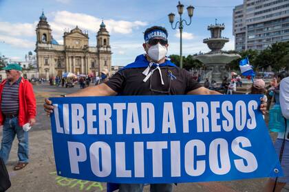 Un ciudadano nicaragüense sostiene un cartel durante una protesta contra el presidente Daniel Ortega en la Plaza de la Constitución en la Ciudad de Guatemala, el domingo 7 de noviembre de 2021. Ortega busca un cuarto mandato consecutivo contra un campo de candidatos poco conocidos, mientras que aquellos que podrían haberle dado un verdadero desafío se sientan en la cárcel. (AP Foto/Moises Castillo)