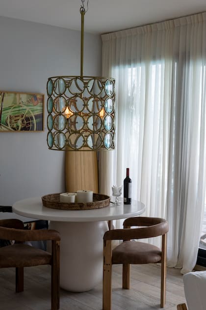 Un clásico que aporta elegancia: las cortinas tradicionales en este pequeño comedor a pasos de la cocina integrada