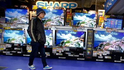 Un cliente pasa frente a unos televisores Sharp. La compañía japonesa aceptó ser adquirida por la compañía taiwanesa Foxconn, fabricante del iPhone