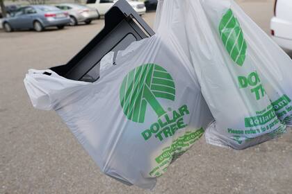 Un cliente sale de una tienda Dollar Tree con una bolsa de compras el miércoles 11 de mayo de 2022, en Jackson, Mississippi
