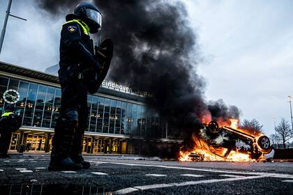 Un coche fue incendiado frente a la estación de tren, el 24 de enero de 2021 en Eindhoven, luego de una manifestación de varios cientos de personas contra las políticas para frenar el coronavirus