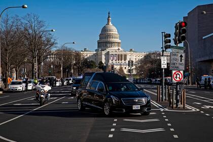 Un coche fúnebre que lleva el ataúd de Brian Sicknick, oficial de policía que murió a causa de las heridas tras el asedio del edificio del Capitolio de Estados Unidos, gira en Constitution Avenue durante una procesión policial el 10 de enero de 2021 en Washington, DC