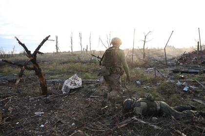 Un comandante ucraniano pasa junto al cuerpo de un soldado ruso muerto en Andriivka, en la región de Donetsk 