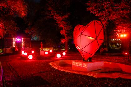 Un corazón se exhibe junto a lámparas que promocionan la marca de uno de los sponsors de la muestra