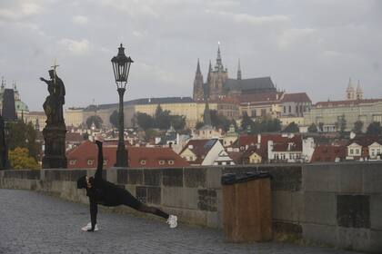 Un corredor elonga en el el vacío Puente de Carlos en Praga, ayer