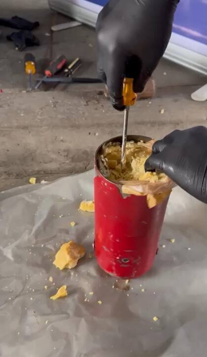 Un cricket hidráulico abierto revela bloques compactos de pasta base de cocaína ocultos en su interior, tras el procedimiento de la Aduana