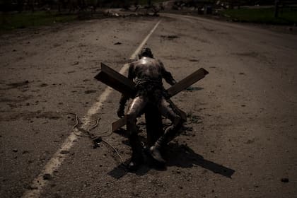 Un cuerpo no identificado con uniforme militar  sobre una barricada cerca de un poblado en las afueras de Kharkiv, Ucrania, el 1 de mayo de 2022