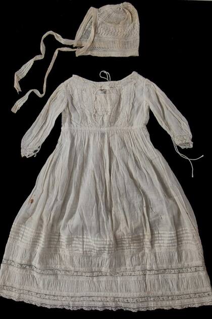 Un delicado conjunto de seda y gorro de Isabel cuando era bebé.