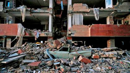 un vehículos aplastado por los escombros que cayeron de un edificio que colapsó tras el terremoto