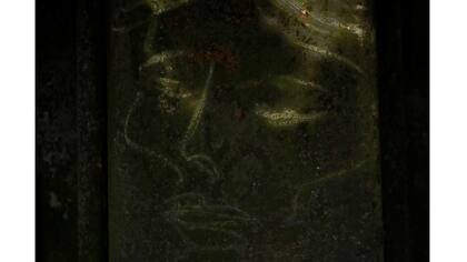 Un dibujo de una cara se ve en una pared de la orilla