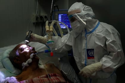 Un doctor examina los ojos de un paciente con Covid-19 en una sala de terapia intensiva en Itauguá, Paraguay