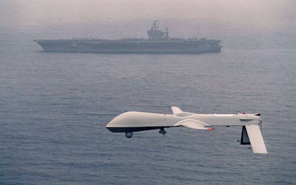 Un dron de las fuerzas armadas de los Estados Unidos junto a un navío de la flota naval norteamericana