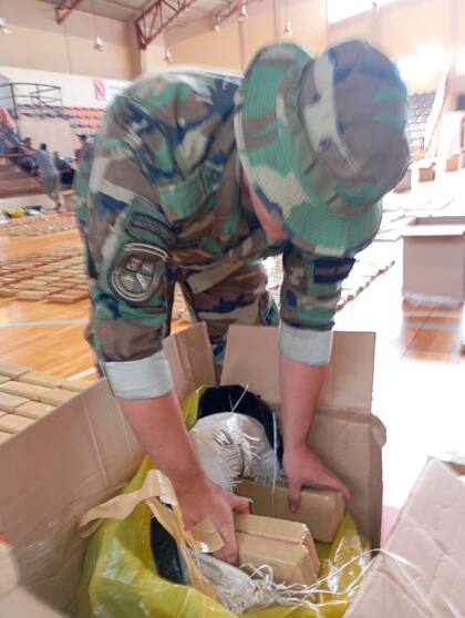 Un efectivo de Prefectura desembala una de las cajas llenas de ladrillos de marihuana