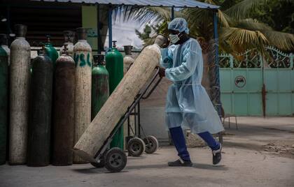 Un empleado de hospital transporta un tubo de oxígeno en Puerto Príncipe