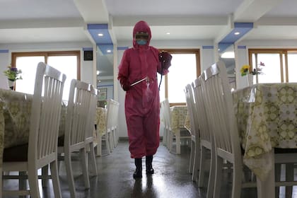 Un empleado de la Fábrica de Productos de Higiene Dental de Pyongyang desinfecta el suelo de un comedor mientras el Estado aumenta las medidas para detener la propagación de enfermedades en Pyongyang, Corea del Norte, el lunes 16 de mayo de 2022.