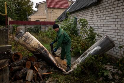 Un empleado municipal ata una cuerda alrededor de los restos de un misil en Kramatorsk