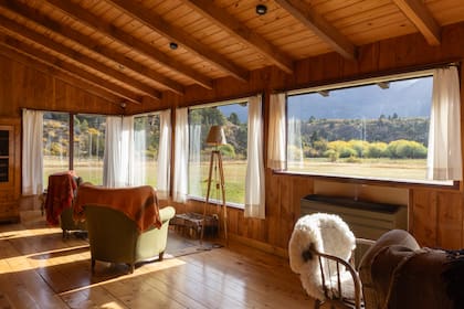 Un enorme salón invita a relajarse frente a la chimenea o a dejarse llevar con la postal cordillerana que ofrecen los ventanales