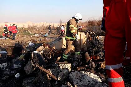 Un equipo de investigadores trabaja entre los escombros del Boeing 737 de Ukraine International Airlines (UIA), derribado el 8 de enero de 2020 en Teherán por un misil