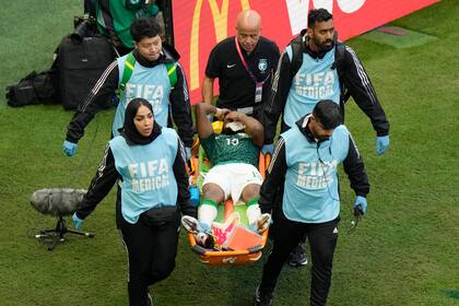Un equipo de paramédicos traslada al defensa saudí Yasser Al-Shahrani en una camilla durante un partido del Grupo C del Mundial entre Argentina y Arabia Saudí, en el estadio de Lusail, en Lusail, Qatar, el 22 de noviembre de 2022. 