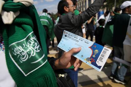 Un espectador muestra la entrada al partido ianugural entre Rusia Arabia y Saudita