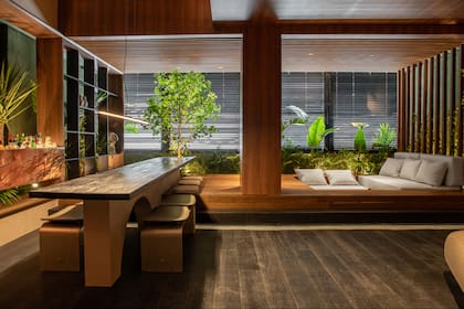 Un estar de encuentro diseñado por Decaro/De Souza y Romano/Cal con un conversation pit rodeado a una exuberante vegetación y una barra moderna para hacer coctelería y degustar en una gran mesa con amigos, completan el espacio los perfiles y detalles de terminaciones de Atrim