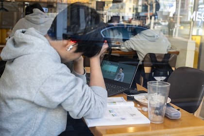 Un estudiante escucha clases en un café de estudio en Seúl el 28 de enero de 2026. La presión académica se ha vuelto tan intensa que incluso los niños de preescolar toman clases extracurriculares privadas, lo que genera preocupación por los derechos de los niños. (Jean Chung/The New York Times)