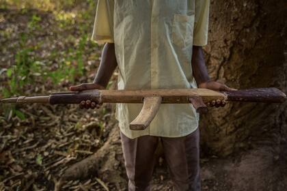 Un ex niño soldado de 11 años posa con su rifle hecho a mano durante la ceremonia de liberación