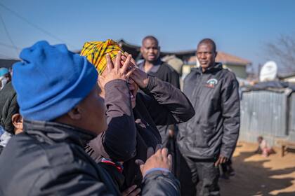 Un familiar de una de las víctimas asesinadas a tiros en una taberna de Soweto reacciona junto a la escena del crimen en Soweto el 10 de julio de 2022.