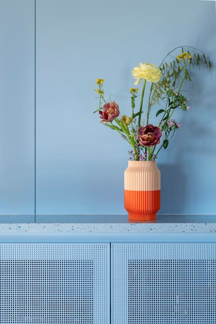 Un florero con arreglo de Irina Khatsernova se adueña de la recepción. En la cocina, se diseñaron muebles con una rejilla que ocultaran los electrodomésticos de la cocina sin encerrarlos. 