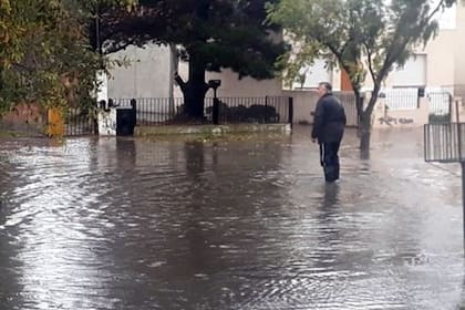 Un hombre cruza la calle inundada