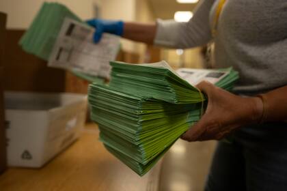 Un funcionario electoral envía papeletas por correo en el Centro Electoral y de Tabulación del condado de Maricopa, en Phoenix, Arizona, el martes 5 de marzo de 2024. (AP Foto/Serkan Gurbuz)